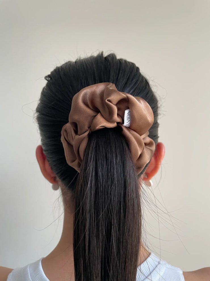 Nutmeg silk hair scrunchie in hair. Classic silk scrunchies are made of 100% silk from up-cycled Italian silk sourced from the Toronto Fashion District. Deadstock that would have otherwise ended up in the trash! Silk is very gentle on your hair! All hair scrunchies are handmade by Siena Vida, a women founded company in Toronto, Canada with a goal of transforming hair accessories to being more environmentally friendly & durable.